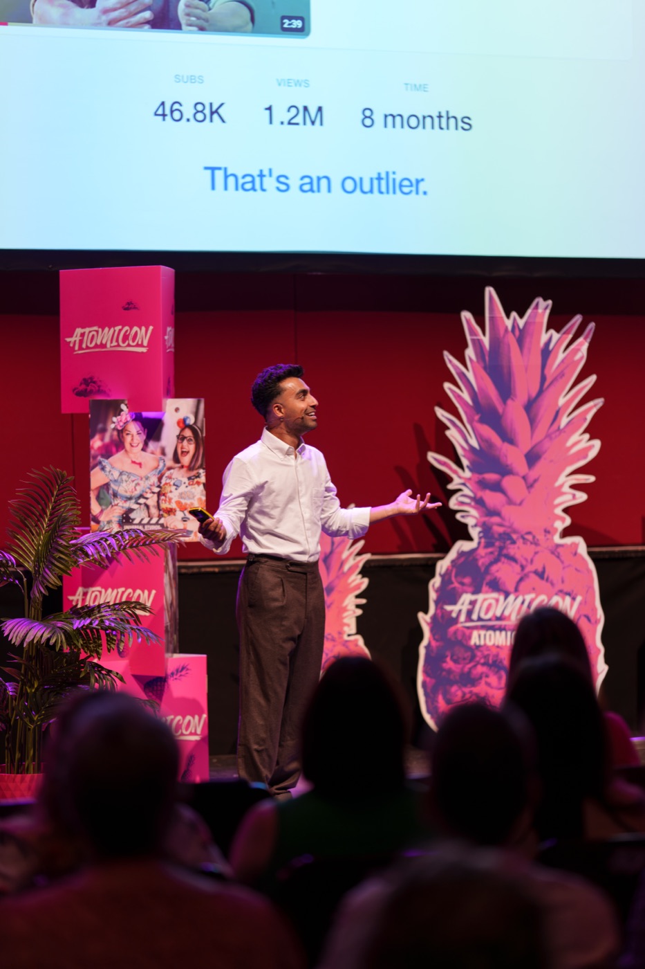 Saf speaking at ATOMICON 2026 in Newcastle, under a slide reading That's an outlier.